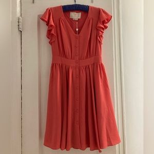Coral colored, ruffled sleeves, gathered waist, front buttons. Lined skirt.